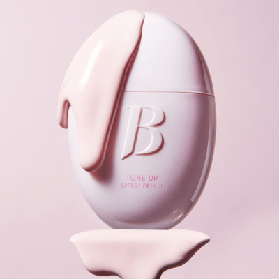 BANILACO All Day Prep Tone Up Base Cream SPF50+PA++++ with pink cream drizzle on egg-shaped bottle, pink background
