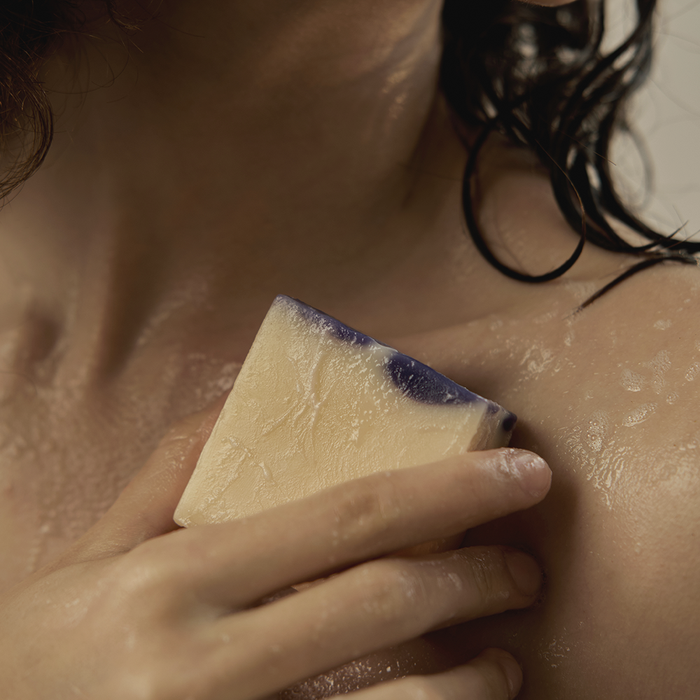 Woman using DONGGUBAT Field Dream Soap Cucumber Eggplant on shoulder