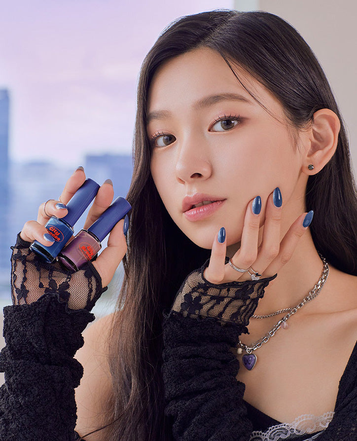Person showcasing blue nail polish and manicure with city skyline in background