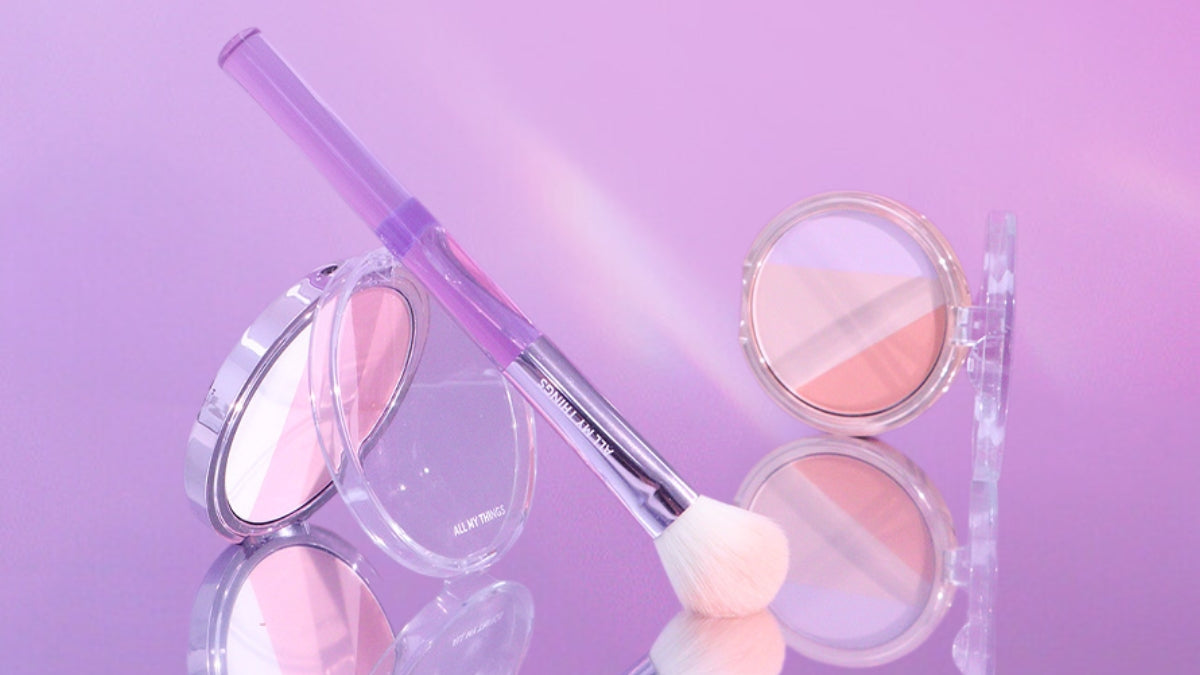 All My Thing: Where each product brings a smile and adds a dash of joy to your day! Makeup brush and blush compacts on a purple background.