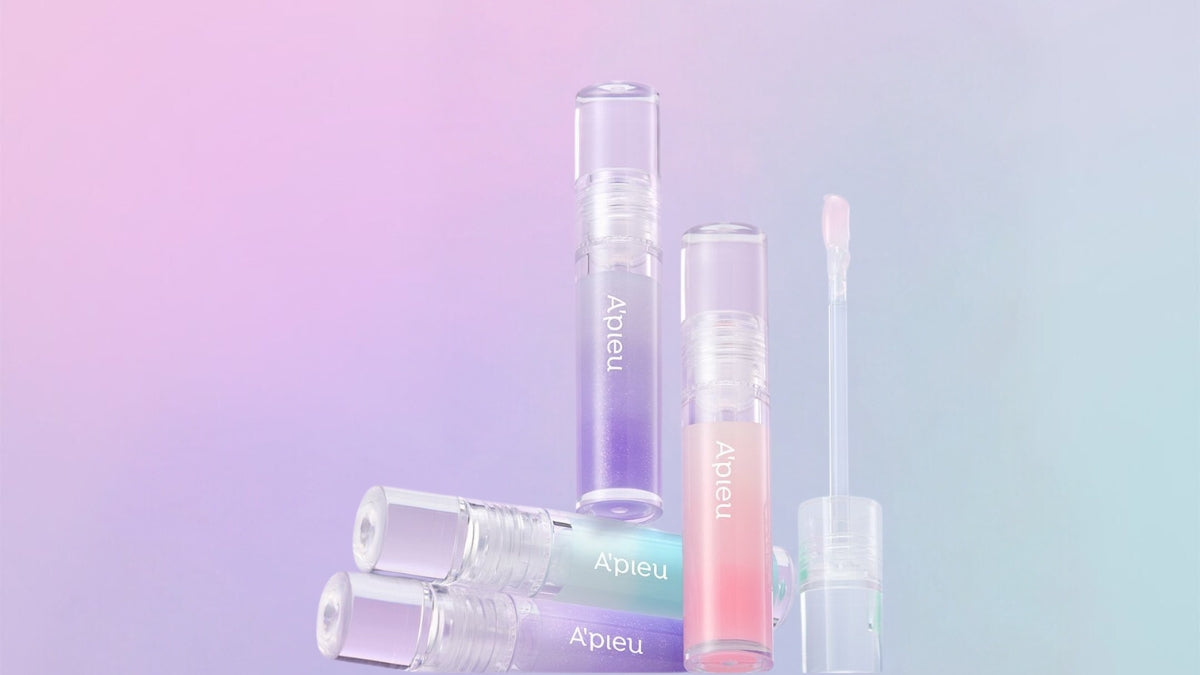 Discover A'PIEU, where playful elegance meets skincare magic with vibrant lip gloss collection against a pastel gradient background.