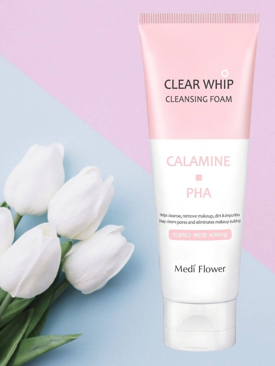 Clear Whip cleansing foam with calamine and PHA by Medi Flower, surrounded by white tulips on a pastel background.