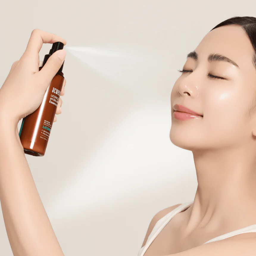 Woman using ACWELL Licorice pH Balancing Essence Mist 100ml on her face for hydration and skin balance.