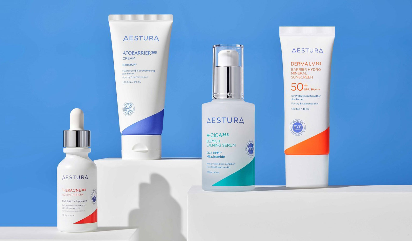 Aestura skincare products displayed on white surfaces against a blue background.