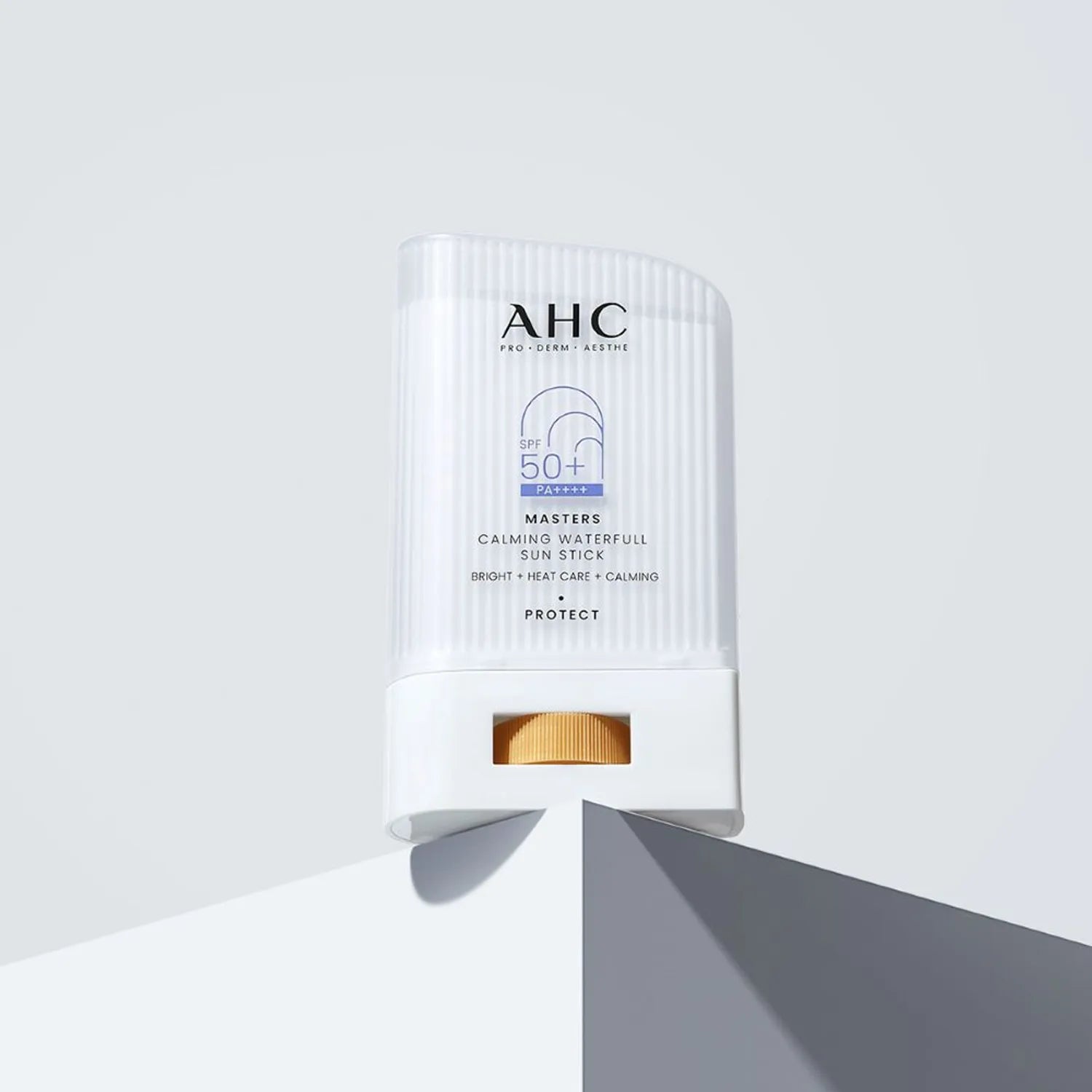 AHC Masters Calming Waterfull Sun Stick 22g placed on a white surface for protection from sun damage.