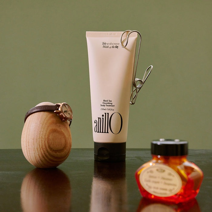 ANILLO Black Tea Nourishing Scalp Treatment 150ml product display with accessories on table.