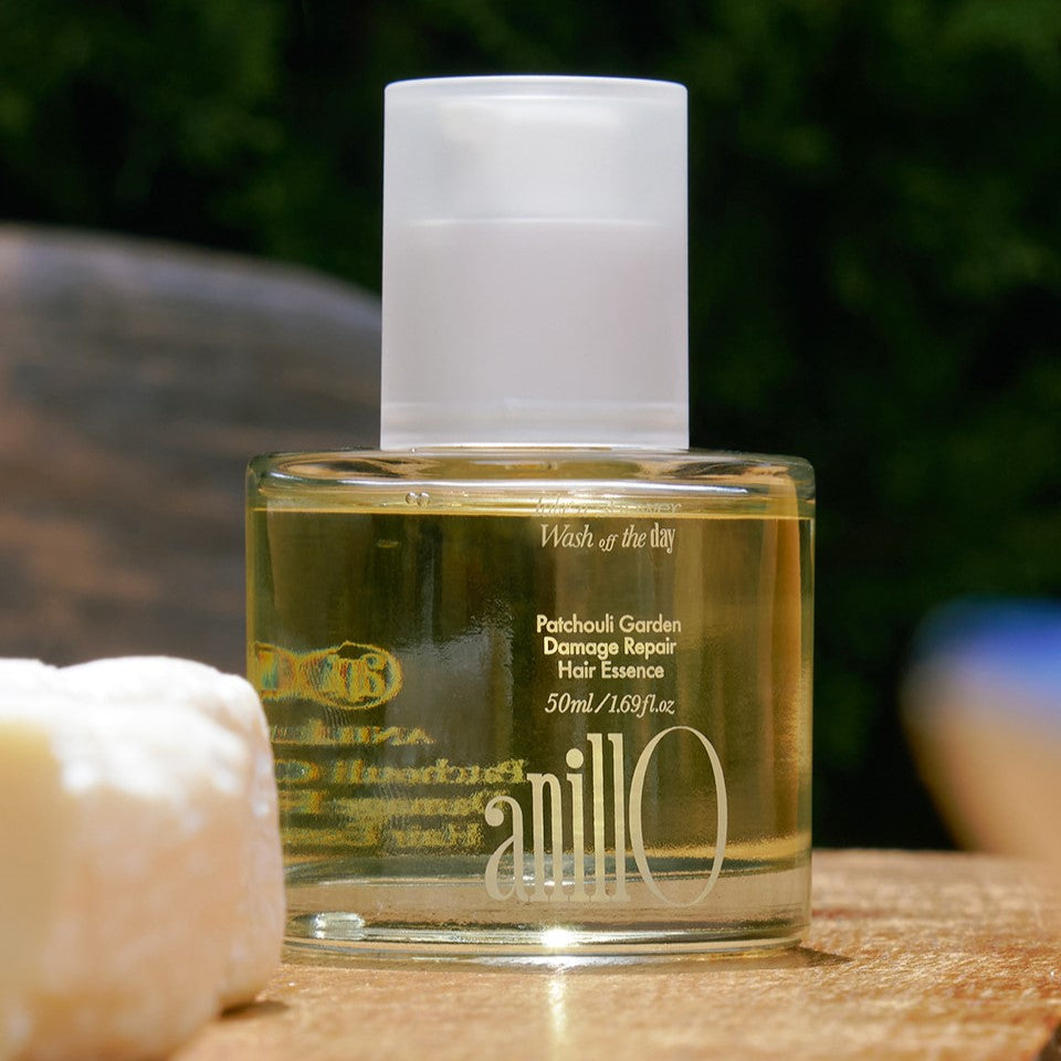 ANILLO Patchouli Garden Damage Repair Hair Essence 50ml bottle on wooden surface outdoors