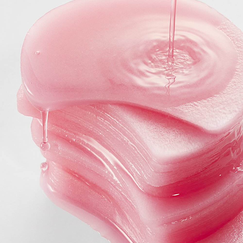 Stack of pink ANUA Niacinamide 5 TXA Brightening Pad 60 Pads with liquid pour to enhance skin brightening effect.
