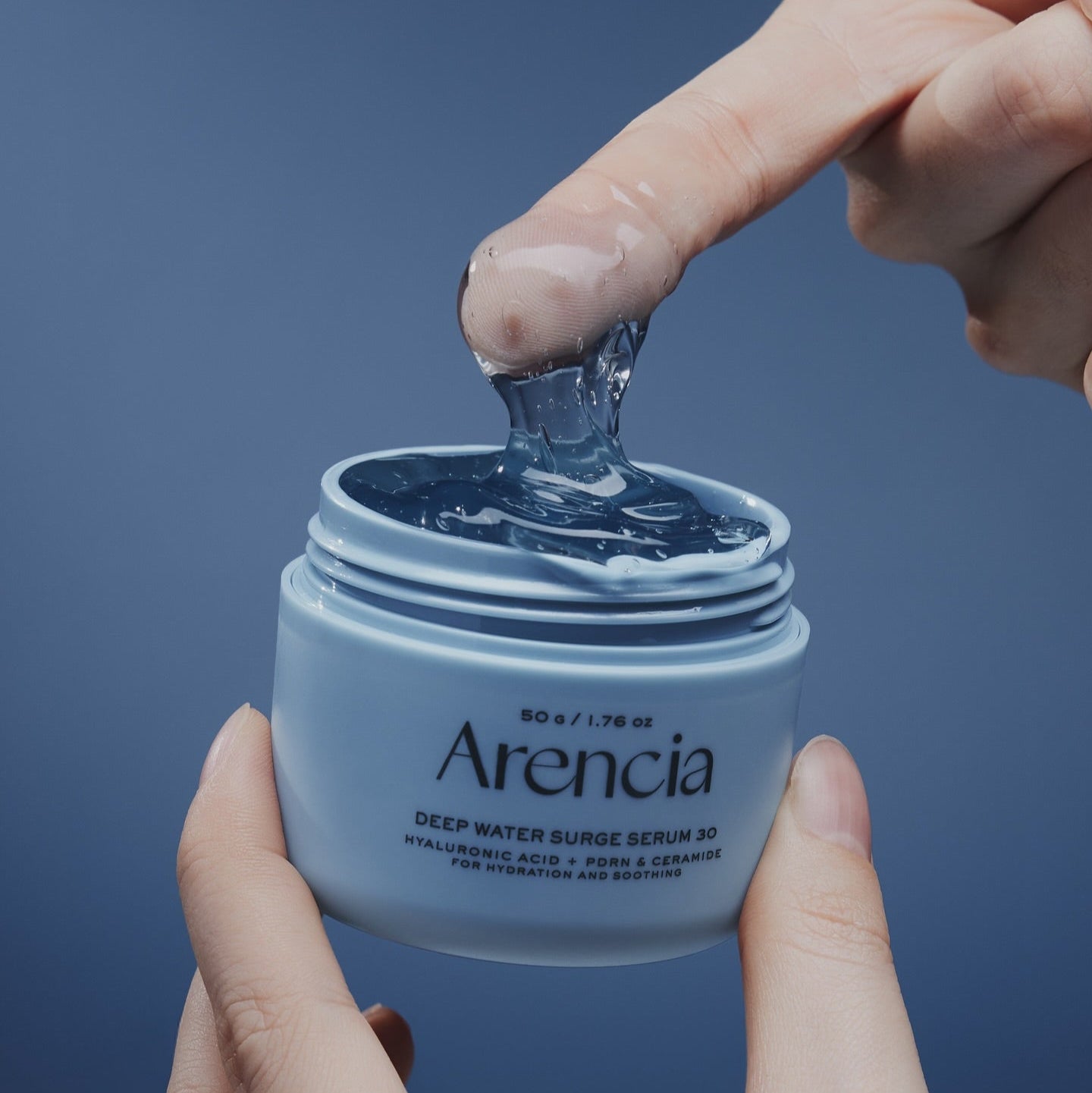 Person using ARENCIA Deep Water Surge Serum 30 50g, showcasing texture and packaging.