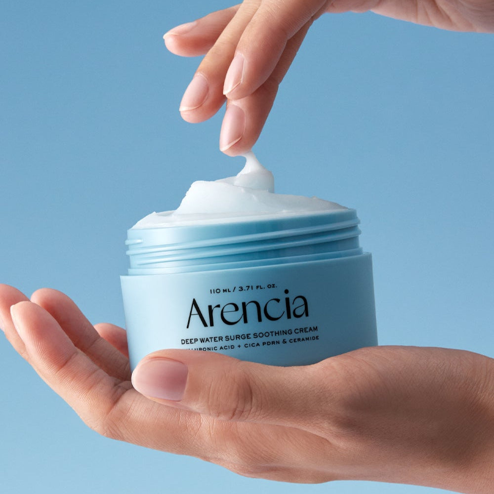 ARENCIA Deep Water Surge Soothing Cream 80ml in open container held in hands against a blue background.