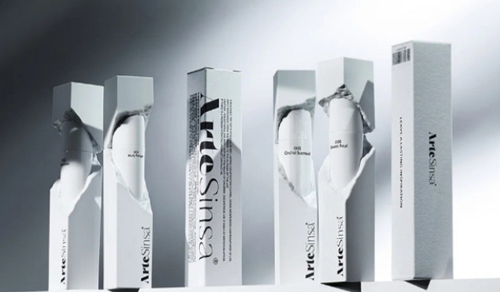 Elegant white ArteSinsa perfume boxes on display, showcasing minimalist and stylish packaging design against a soft background.