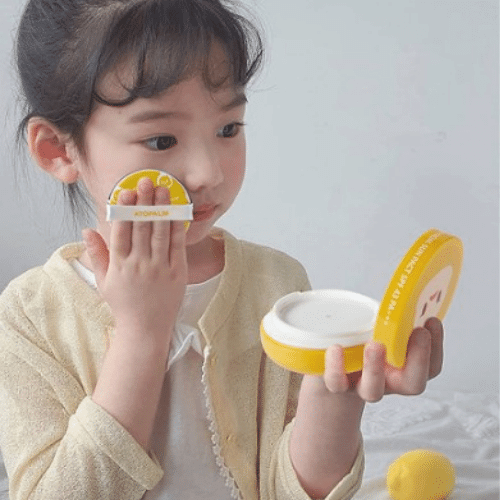 Child applying ATOPALM Toktok Facial Sun Pact SPF43 PA+++ 15g with included applicator, showcasing sun protection skincare product use.