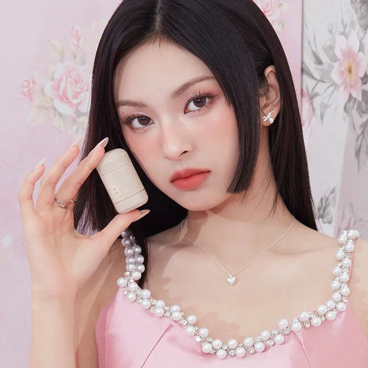 Model showcasing BANILA CO Romantic Blush Contour with floral backdrop and elegant attire.