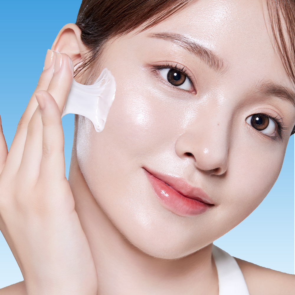 Model applying BANOBAGI PDRN 1000 Anti-Aging Cream 50ml to face on a blue background.