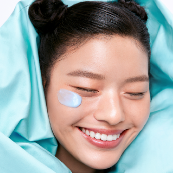 Smiling woman with smooth skin using BELIF Aqua Bomb Frozen Modeling Mask for hydration and glow.