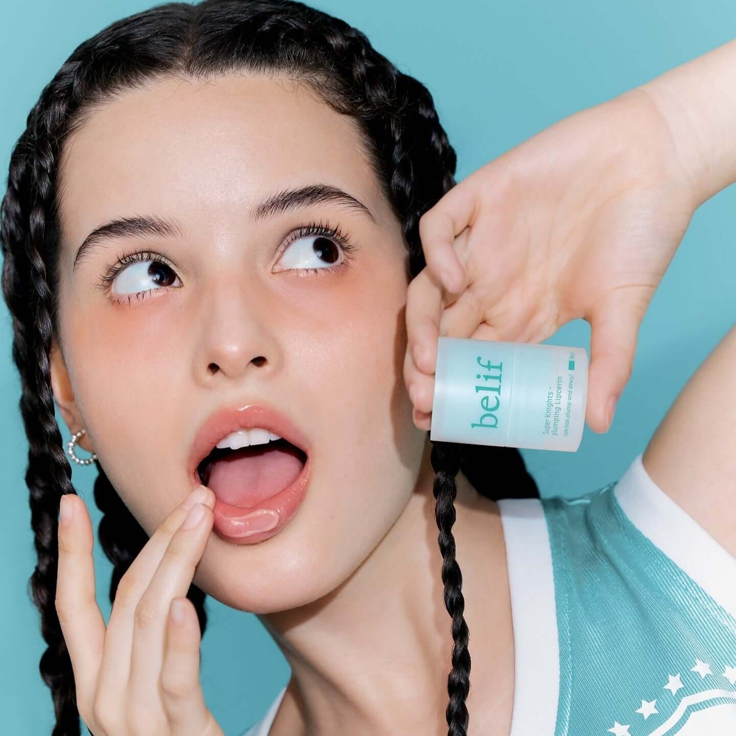 Woman applying BELIF Super Knight Mint Plumping Lipcerine with an excited expression.