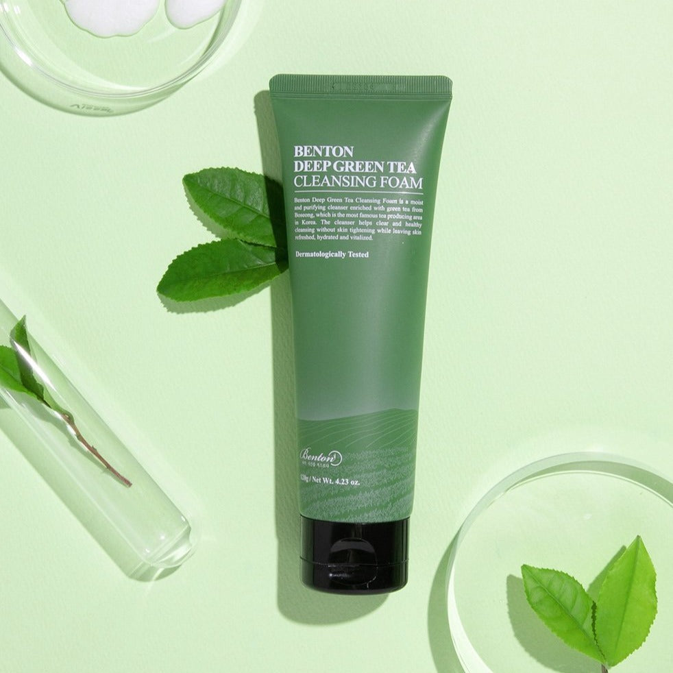 BENTON Deep Green Tea Cleansing Foam 120g tube on light green background with green tea leaves and test tubes.
