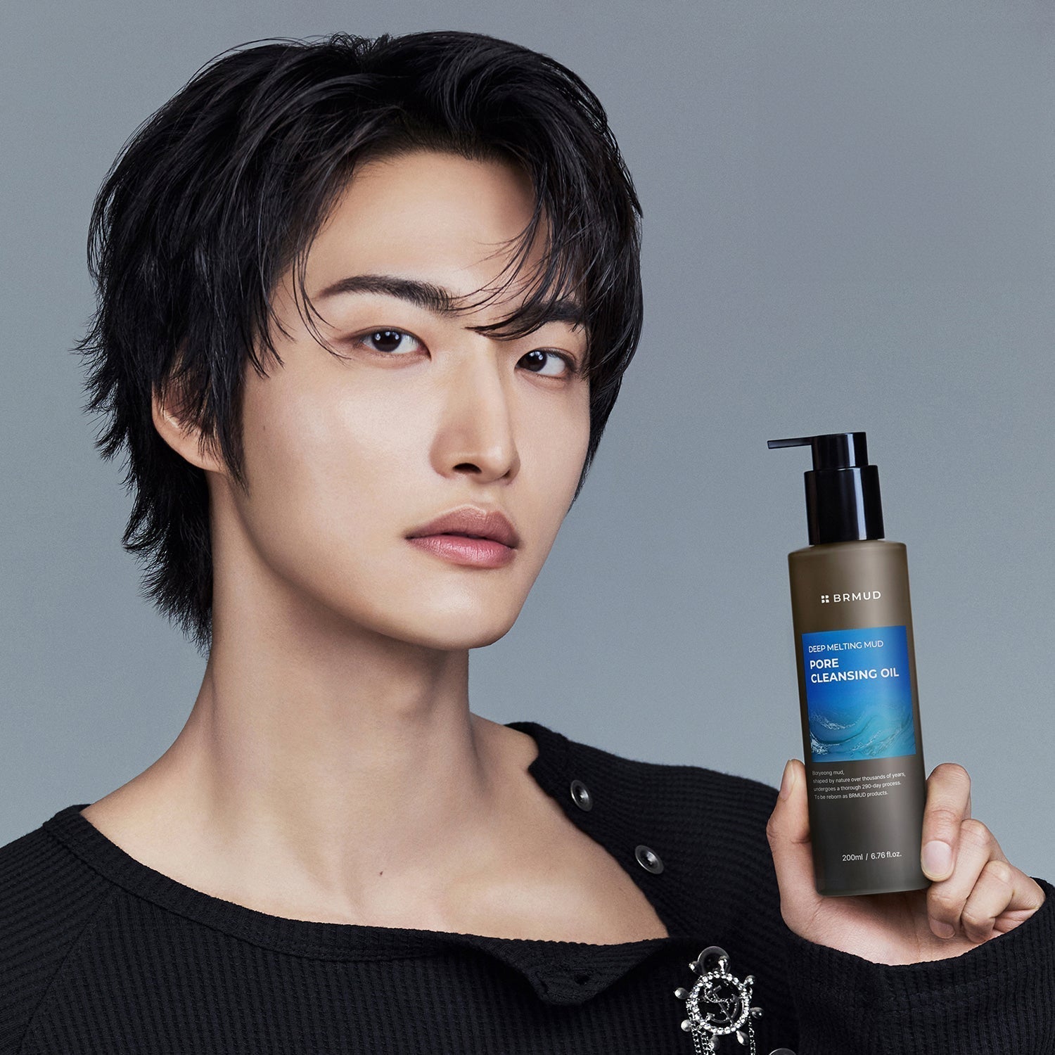 BRMUD Deep melting Mud Pore Cleansing Oil 200ML bottle held by stylish Korean gentleman model – Gentleman Korea men’s skincare product