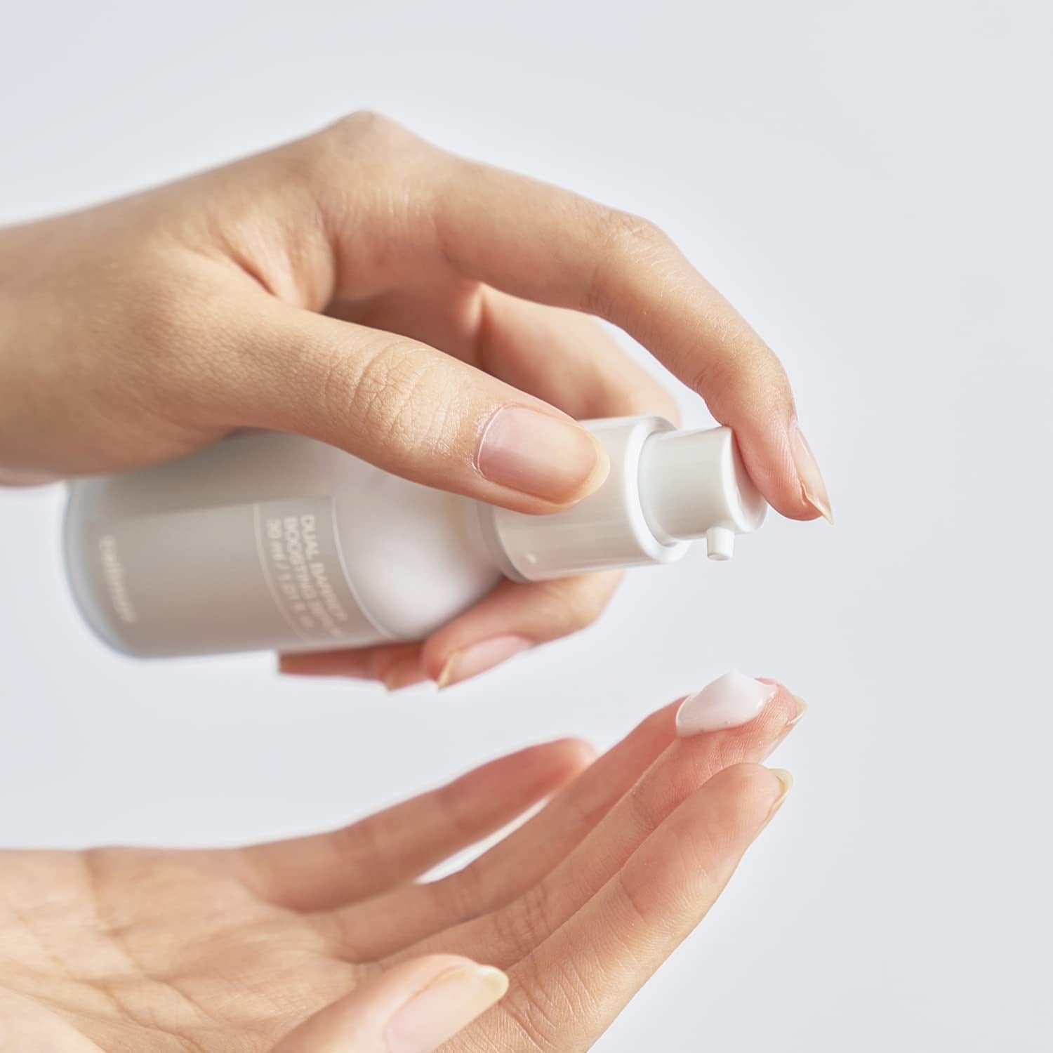 Applying CELIMAX Dual Barrier Boosting Serum 30ml on skin for hydration and protection.