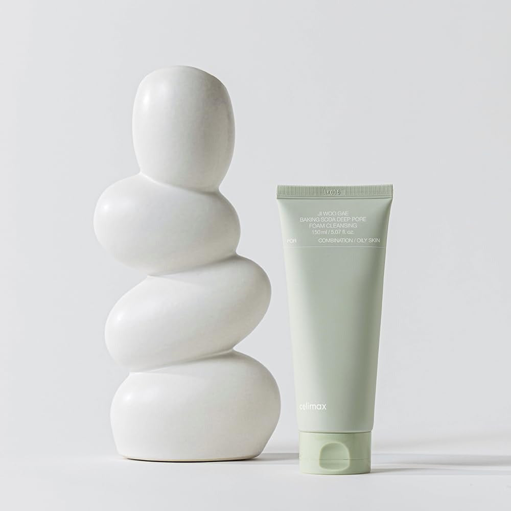 CELIMAX Ji Woo Gae Baking Soda Deep Pore Foam Cleansing 150ml tube next to white sculpture for facial care