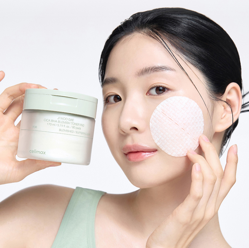 Woman using CELIMAX Ji Woo Gae Cica BHA Blemish Toner Pad 60 pads for skincare routine.