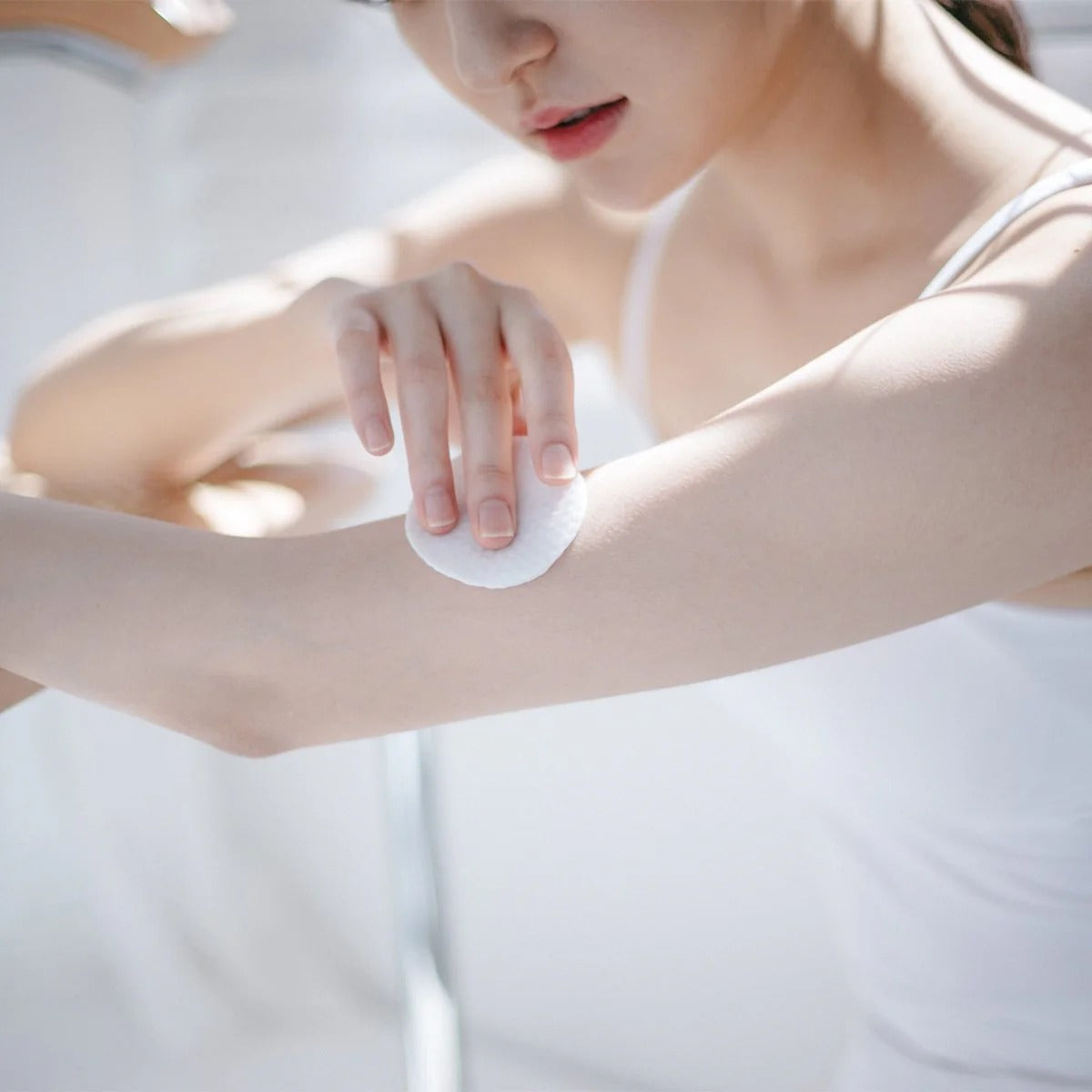 Using CELIMAX Ji Woo Gae One Step Body Brightening Pad 60 Pads on arm for skin care