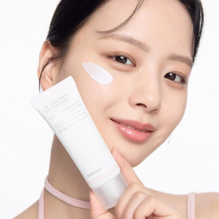 Person applying CELIMAX Oil Control Light Sunscreen 40ml with SPF 50 to face for sun protection and oil control.