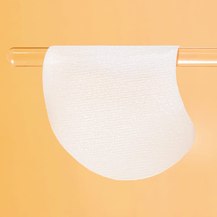 CELIMAX Pore Dark Spot Brightening Pad 40ea displayed on a clear rod against an orange background