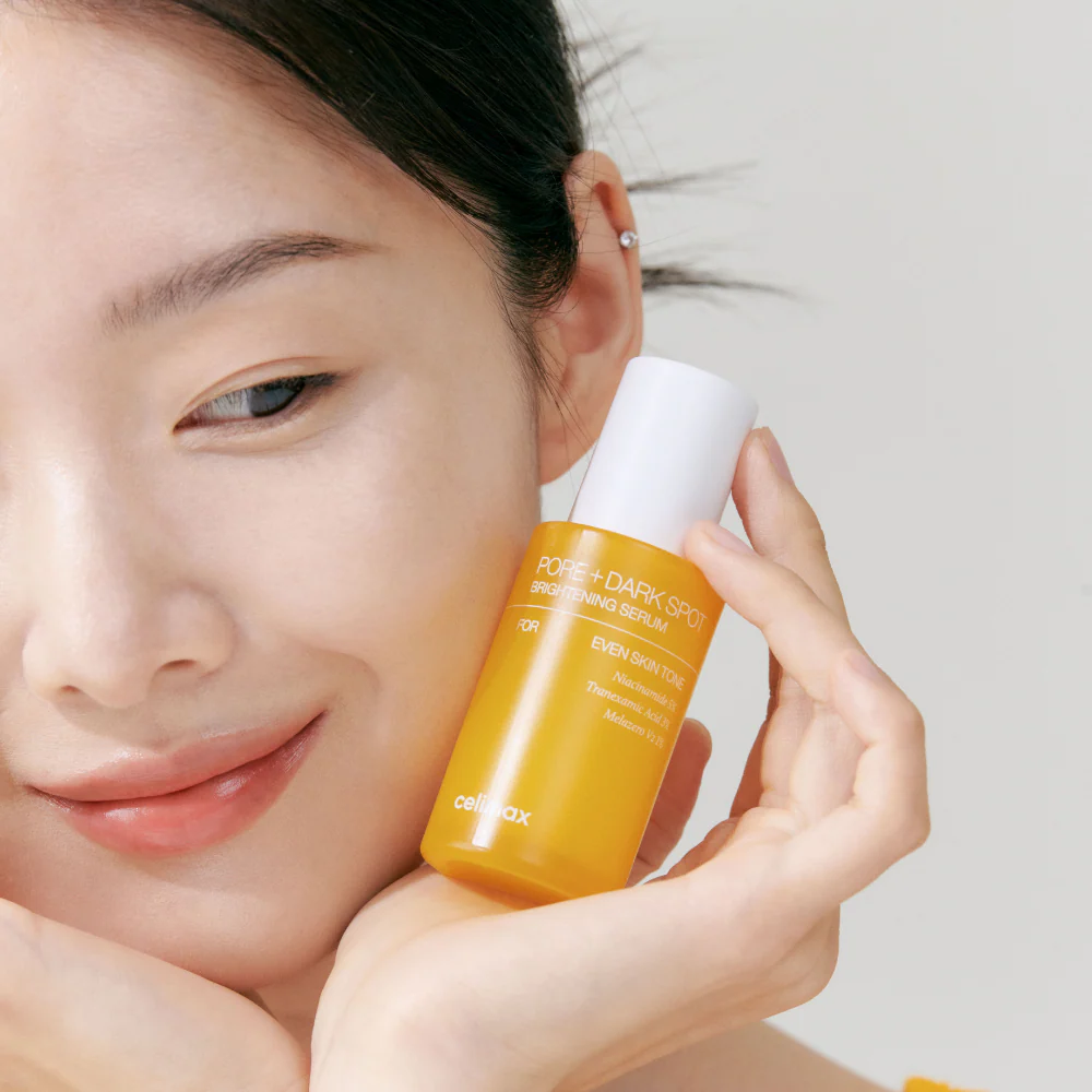 Woman holding CELIMAX Pore Dark Spot brightening Serum 30ml, showcasing skincare benefits.
