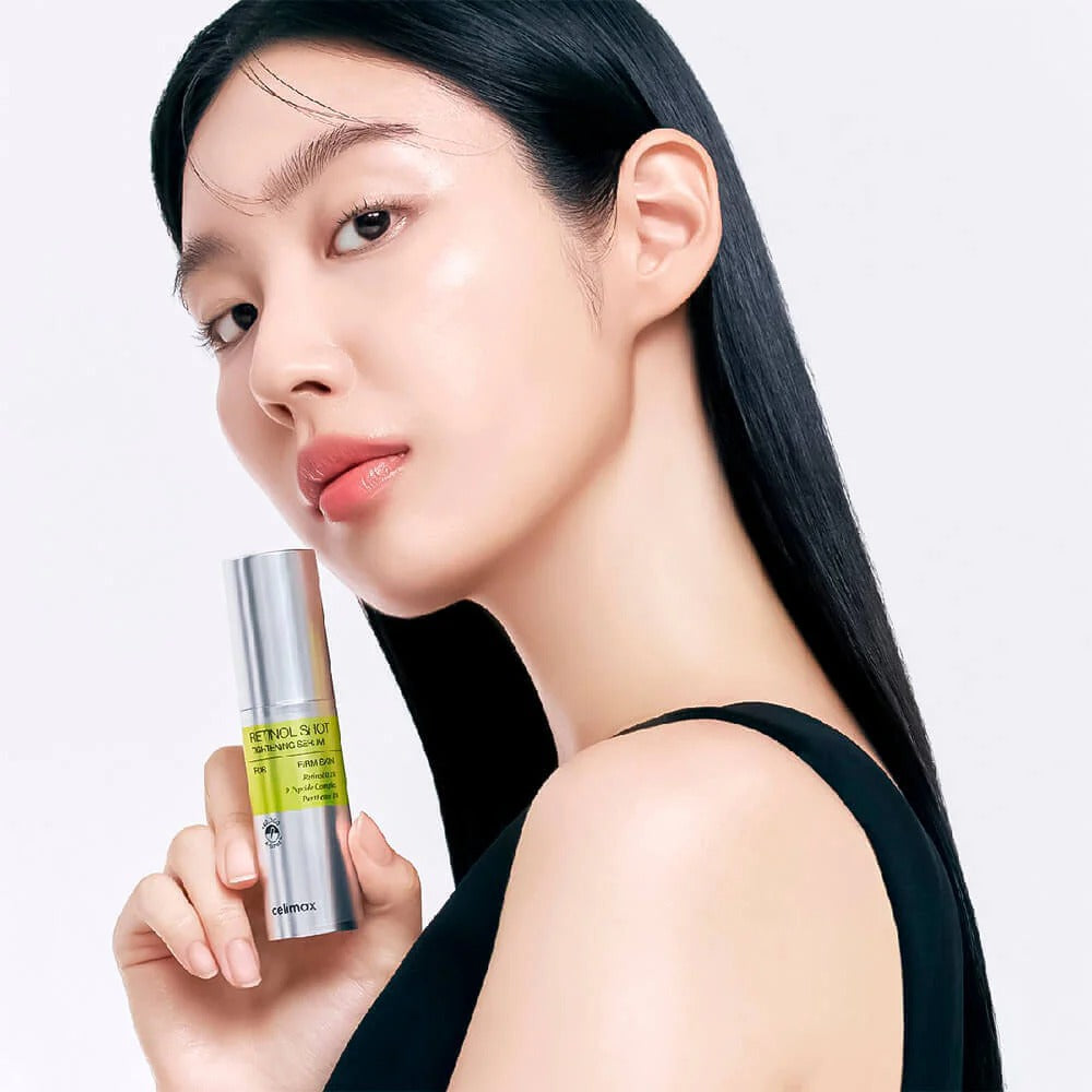 Woman holding CELIMAX Retinol Shot Tightening Serum 30ml against white background.