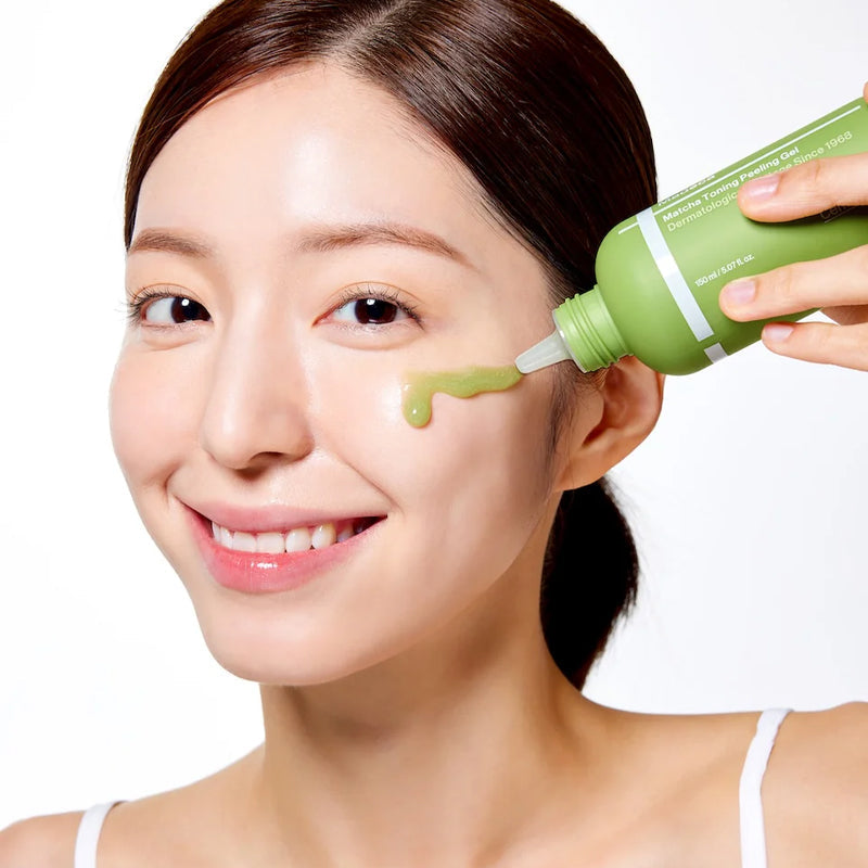 Smiling woman applying CENTELLIAN 24 Madeca Matcha Toning Peeling Gel 150ml to her face from a green bottle.