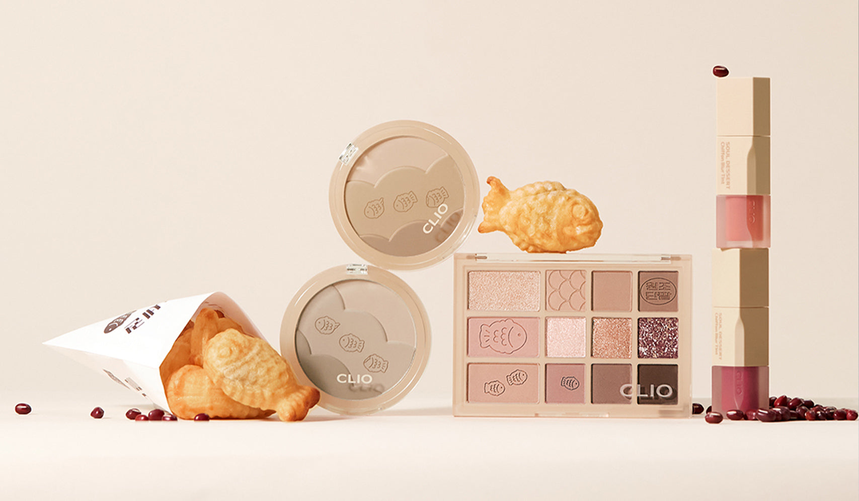 Makeup set featuring eyeshadow palette, compacts, and lip products with pastry-like packaging and decorative elements.