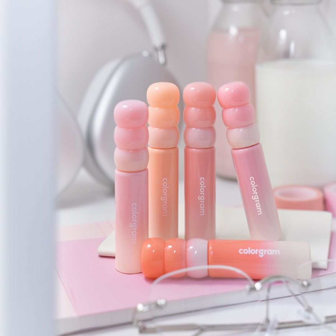 COLORGRAM Tanghulu Tangle Tint Milk 3g lip tints displayed on a vanity table with makeup essentials in soft pastel shades.