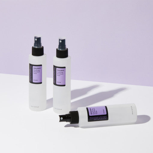 Three bottles of COSRX AHA/BHA Clarifying Treatment Toner 150ml displayed on a white surface with a lavender backdrop.