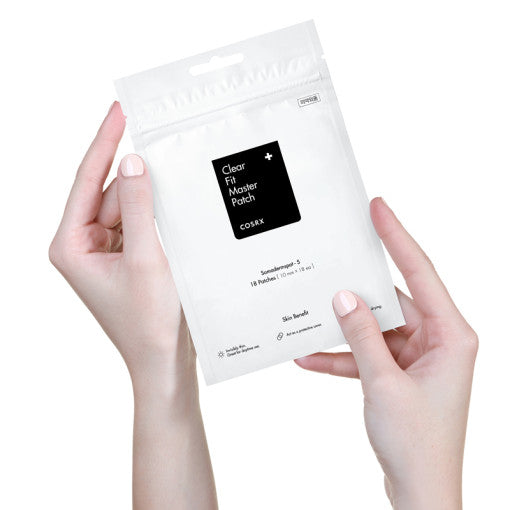 Hands holding a package of COSRX Clear Fit Master Patch 18p for acne treatment.