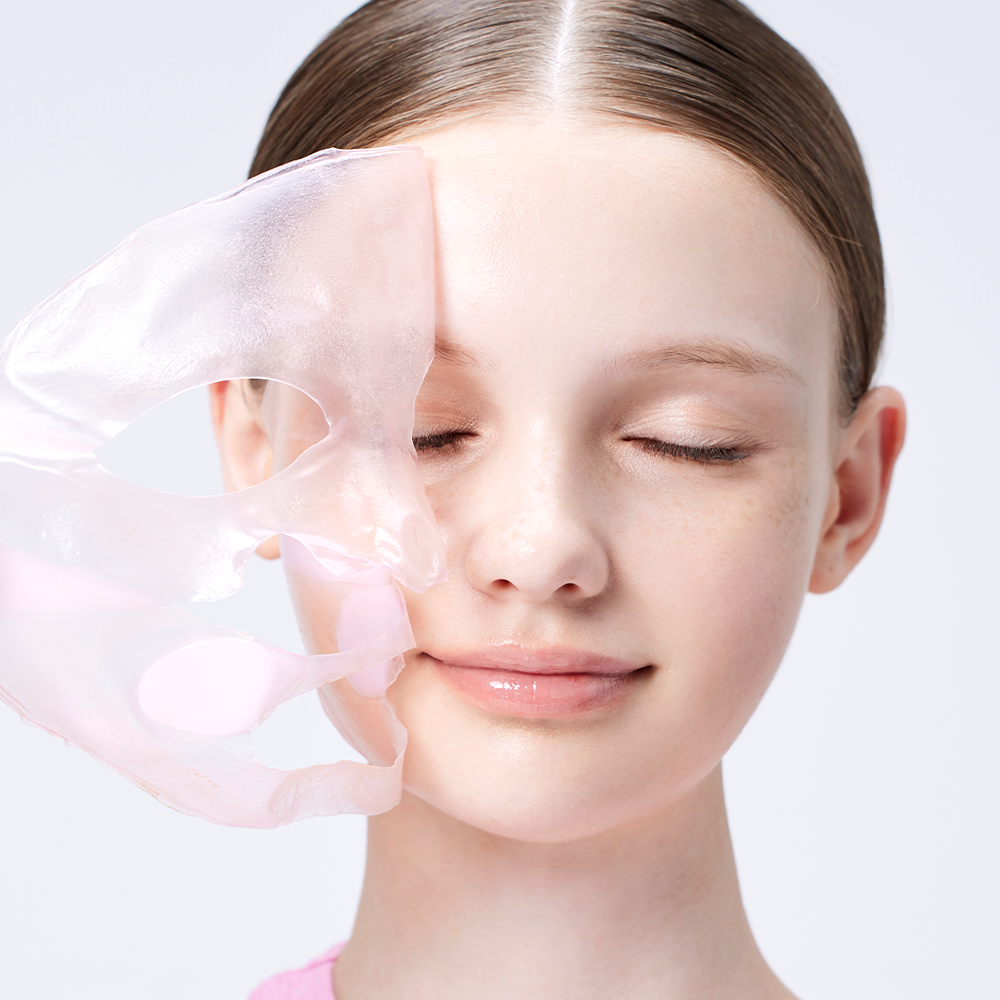 Woman applying COSRX The Peptide Collagen Lifting Glow Hydrogel Mask (3 sheets) to her face for skincare