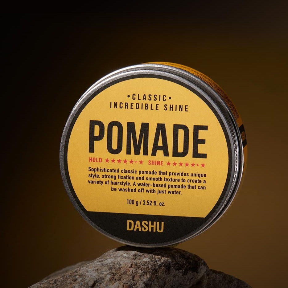 DASHU Classic Incredible Shine Pomade 100g - Gentleman Korea product shot of yellow tin on rock, classic high-shine men’s styling wax