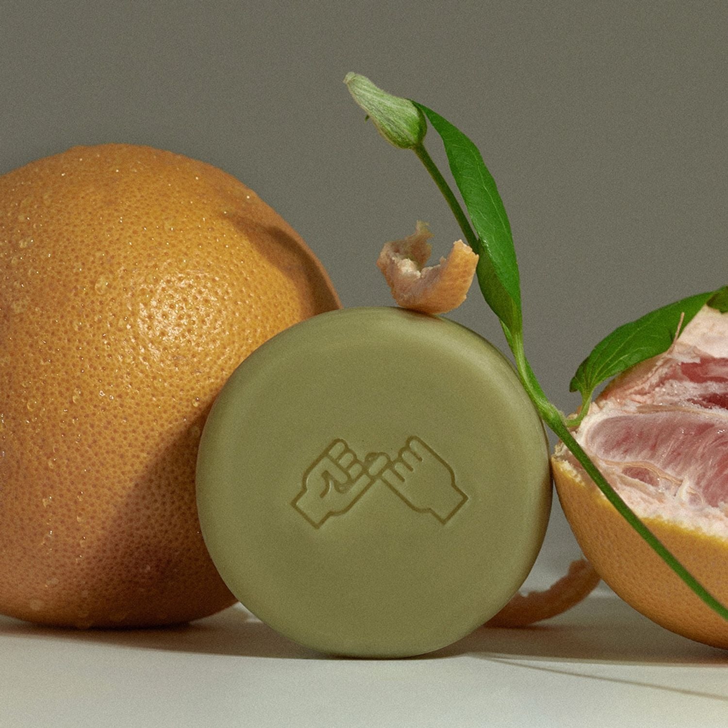 DONGGUBAT Correct Shampoo Bar For Dry Skin next to fresh grapefruit, illustrating its natural ingredients and eco-friendly appeal.
