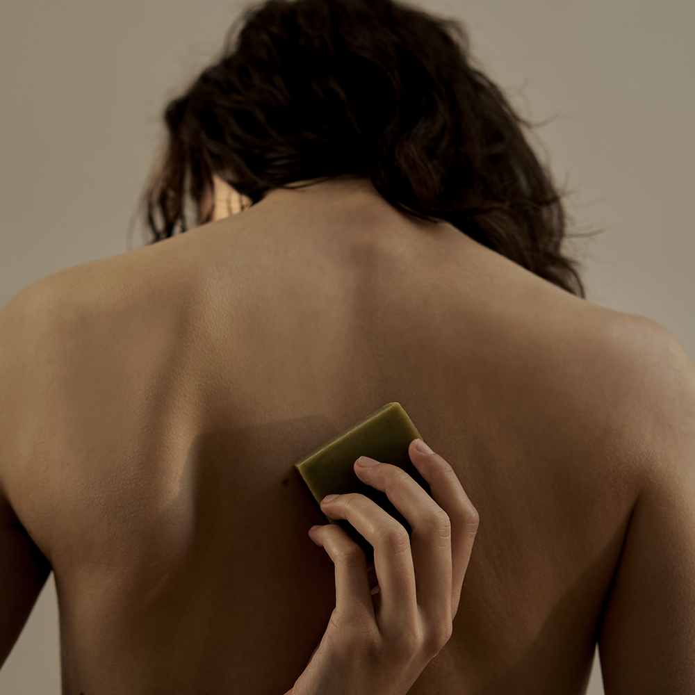 Person using DONGGUBAT Dream Soap Lattuce on back for skincare