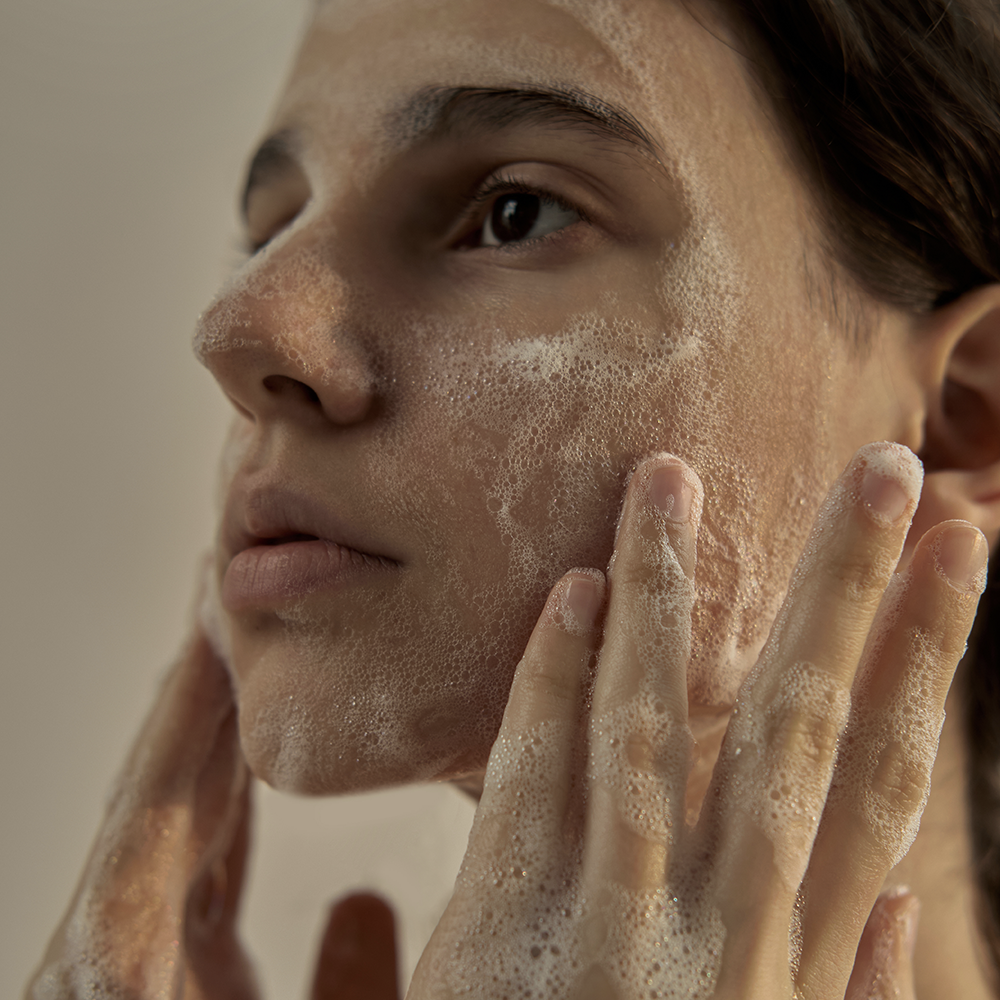 Woman washing face with DONGGUBAT Field Dream Soap Basil for clear skin