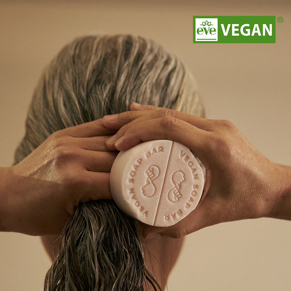 Person using DONGGUBAT Vegan Treatment Bar Dongbaek on wet hair, highlighting eco-friendly and vegan features.