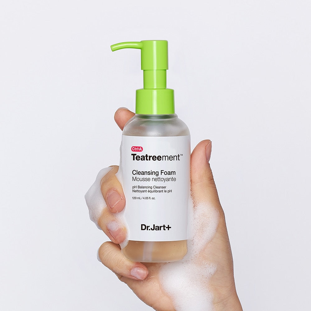 Hand holding DR. JART+ Ctrl-A Teatreement Cleansing Foam 120ml bottle with foamy texture