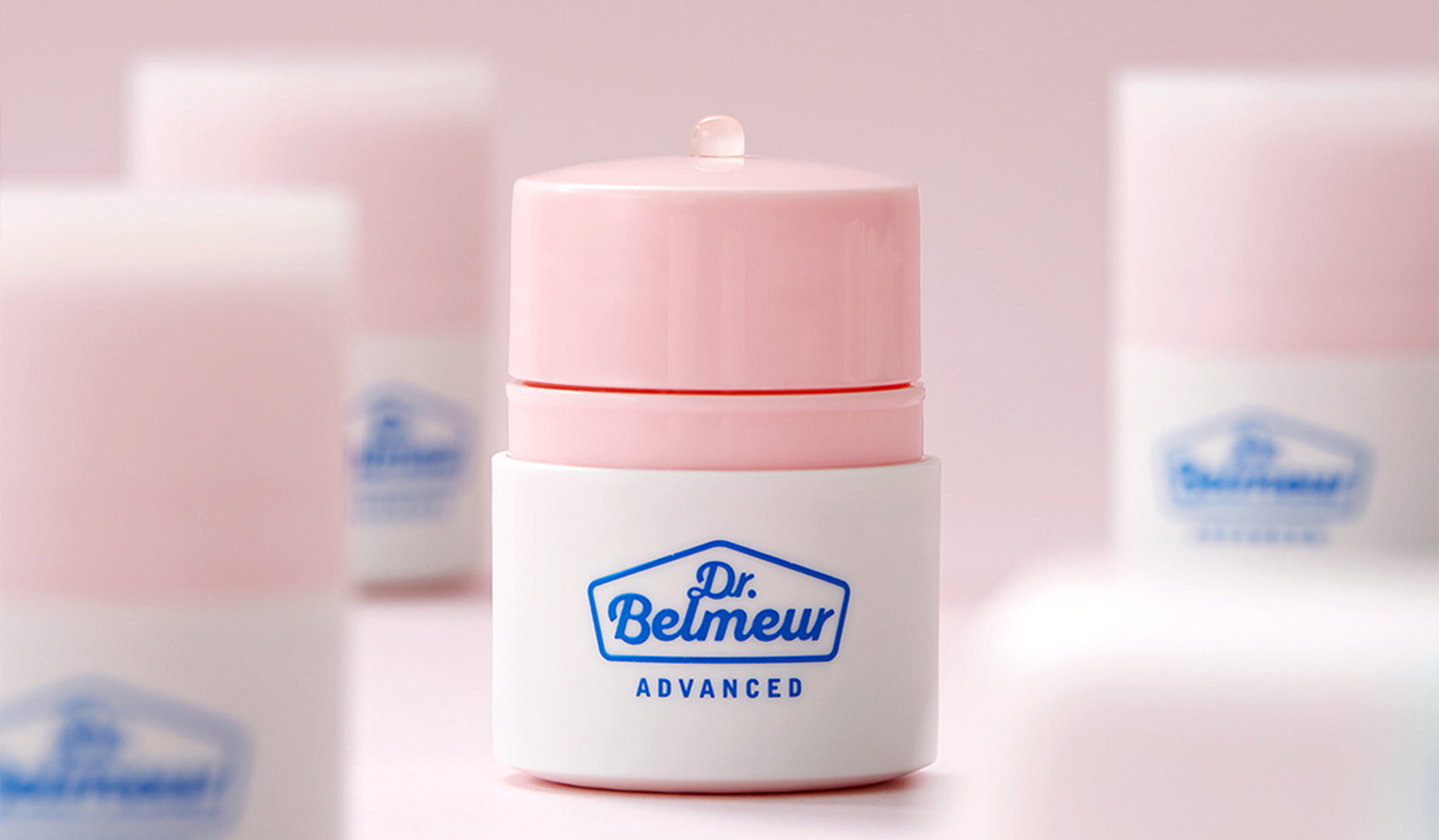 Dr. Belmeur Advanced skincare bottles with pink caps on a soft pink background, showcasing luxury beauty products.