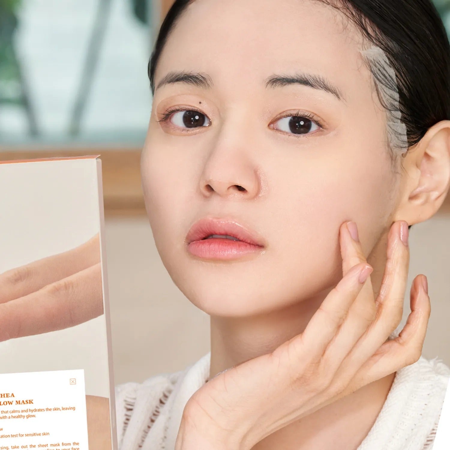 Person holding DR.ALTHEA Vita glow Mask (4ea) and touching face, depicting skincare routine and product application.