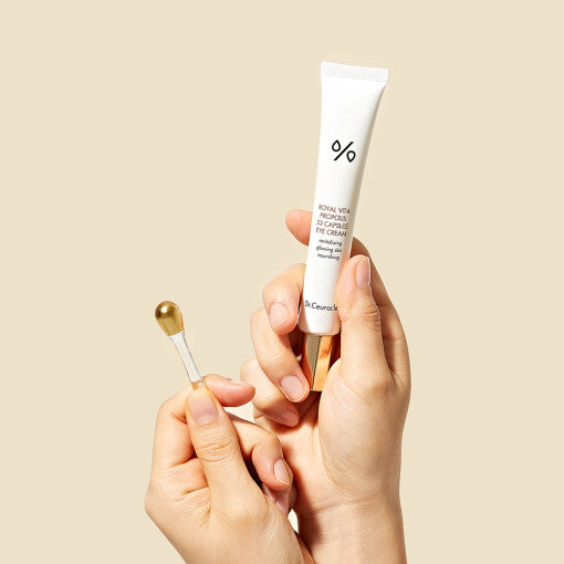 DR.CEURACLE Royal Vita Propolis 33 Capsule Eye Cream 20ml on beige background with applicator, enhancing eye skincare routine.