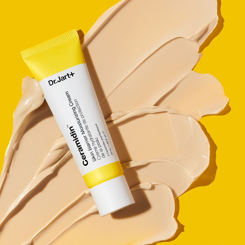 DR.JART+ Ceramidin Skin Barrier Moisturizing Cream 50ml tube on cream swatches against a yellow background