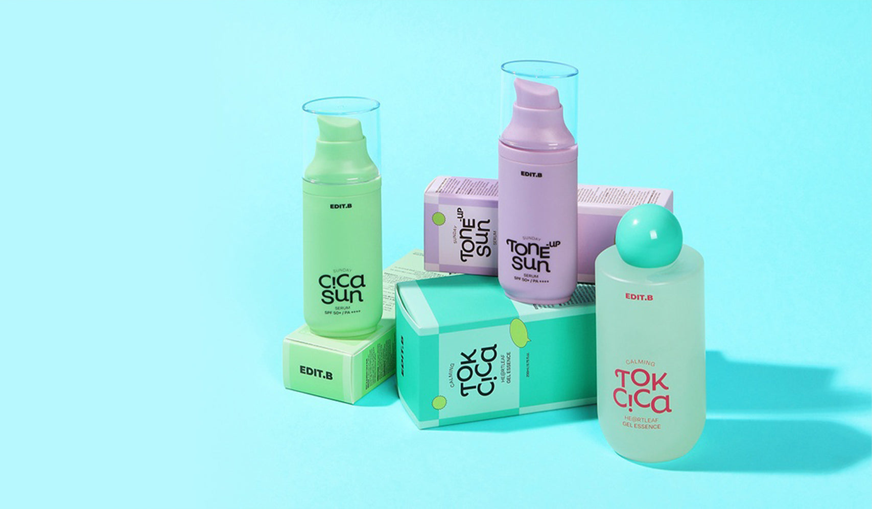 Assorted skincare products in pastel green and pink packaging on a blue background, including lotions and creams labeled Cica Sun, Tone Sun, and Tok Cica.