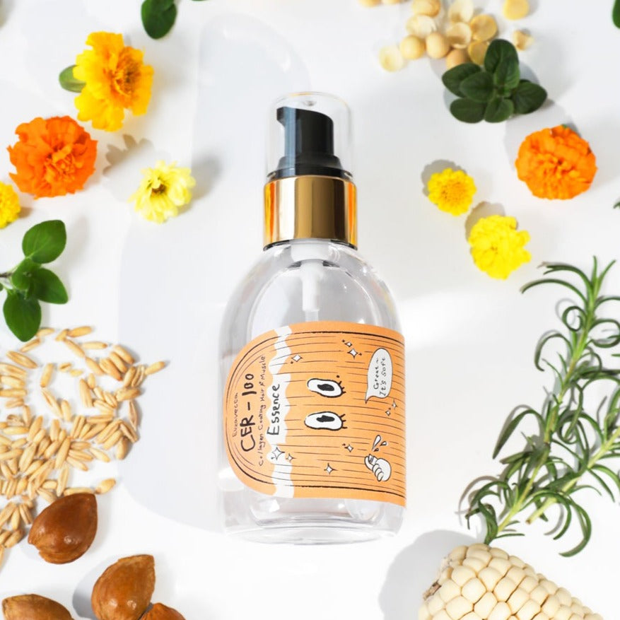 ELIZAVECCA Cer-100 Collagen Coating Hair A+ Massage Essence 150ml bottle surrounded by natural ingredients and flowers.
