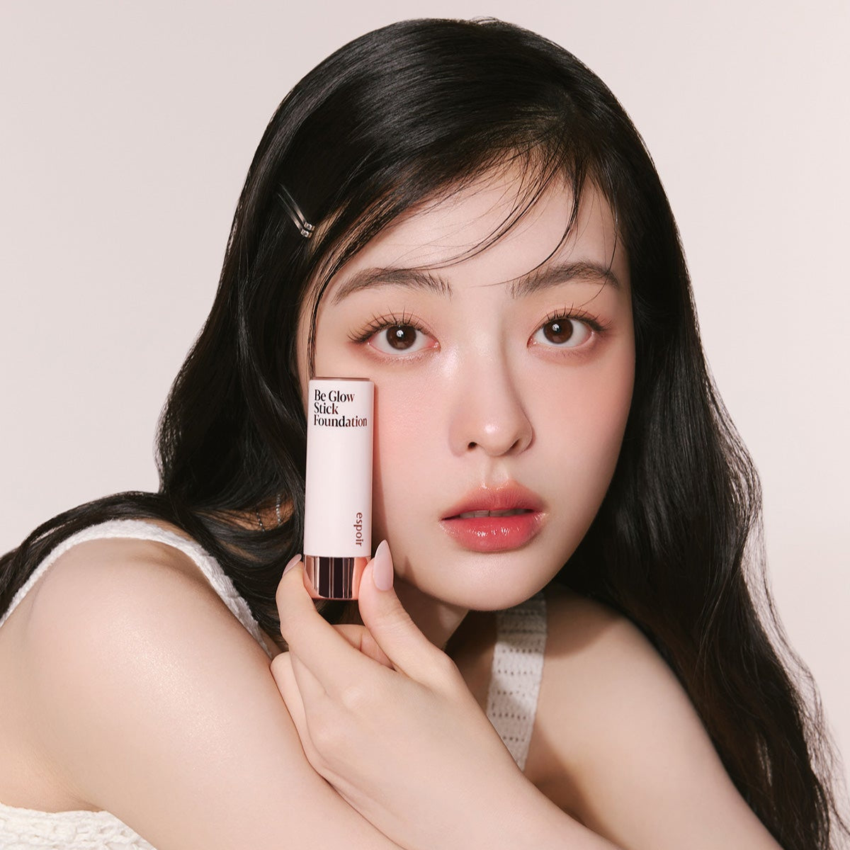 Woman holding ESPOIR BE GLOW STICK FOUNDATION SPF50+ PA++++ product.
