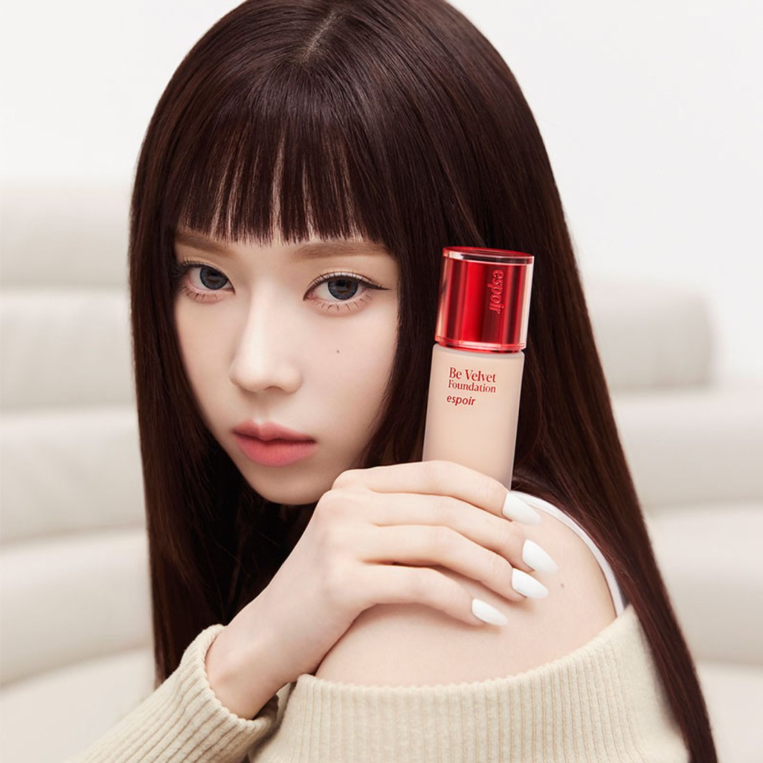 Model holding ESPOIR BE VELVET FOUNDATION SPF22 PA++ showcasing luxurious skin coverage.